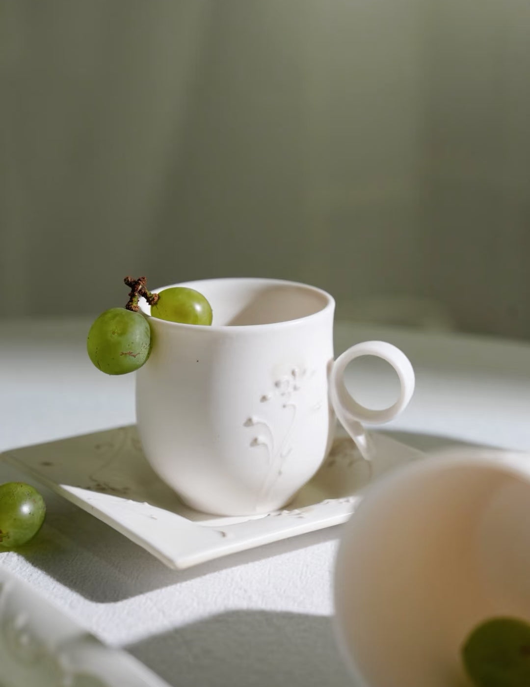 Kilnora Sōng Dandelion Series matte white ceramic cup with freehand slip motifs and mineral powder accents