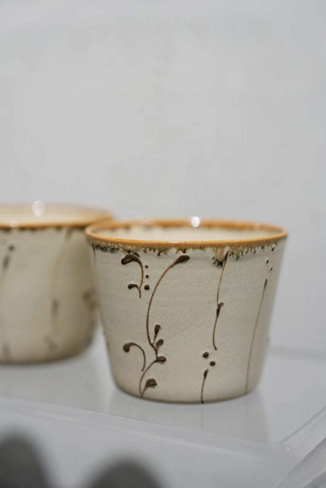 Kilnora Sōng Amber Series ceramic Chyongku cup with warm amber glaze and hand-painted slip motifs