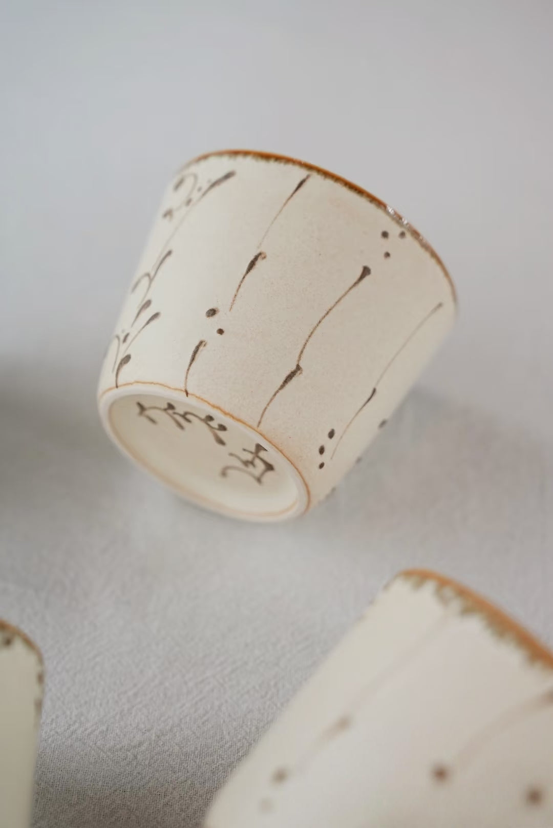Kilnora Sōng Amber Series ceramic Chyongku cup with warm amber glaze and hand-painted slip motifs