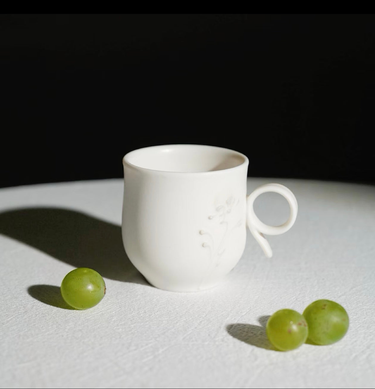 Kilnora Sōng Dandelion Series matte white ceramic cup with freehand slip motifs and mineral powder accents
