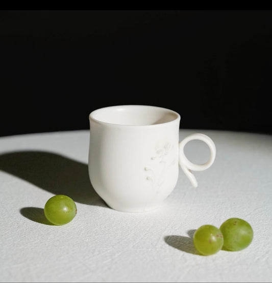Kilnora Sōng Dandelion Series matte white ceramic cup with freehand slip motifs and mineral powder accents
